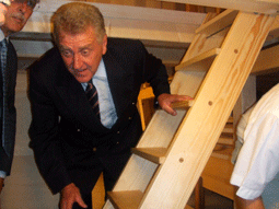 Wirtschaftsminister Ernst Pfister  in der Balgkammer unter der Orgel, um das Innenleben des Instruments zu begutachten